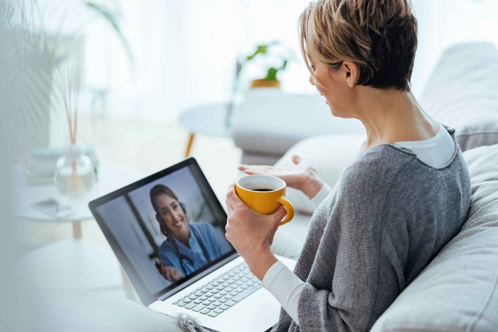 woman-using-laptop-having-video-call-with-her-doctor-while-sitting-home