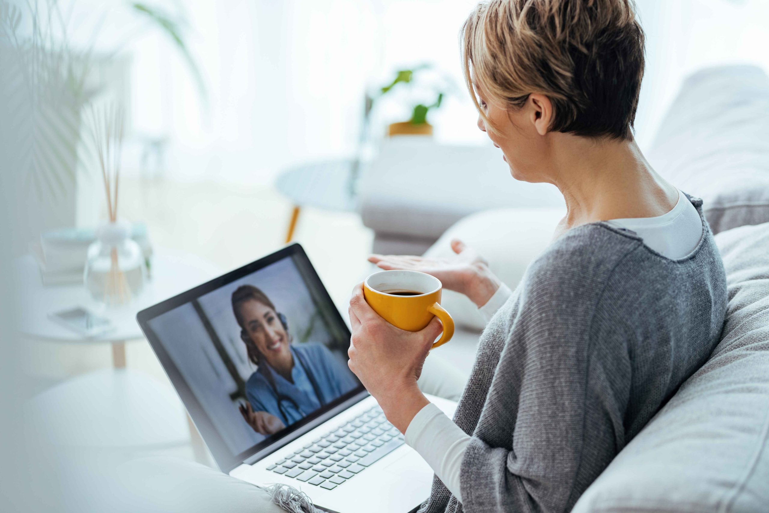 woman-using-laptop-having-video-call-with-her-doctor-while-sitting-home